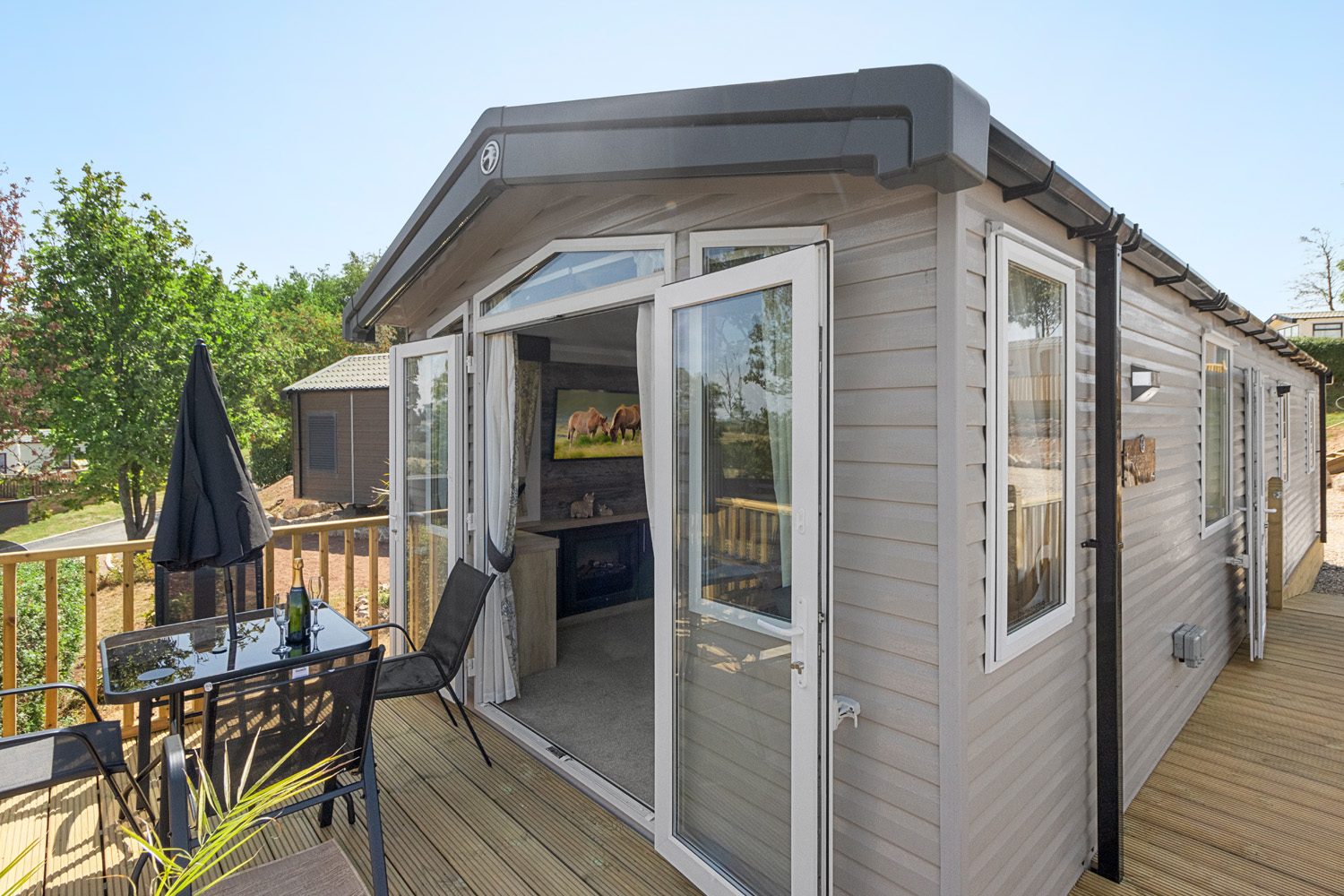 Exterior view of the caravan with open patio doors onto the terrace