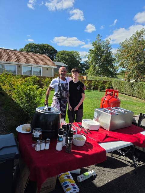 Hog roast stand being run at a park social event